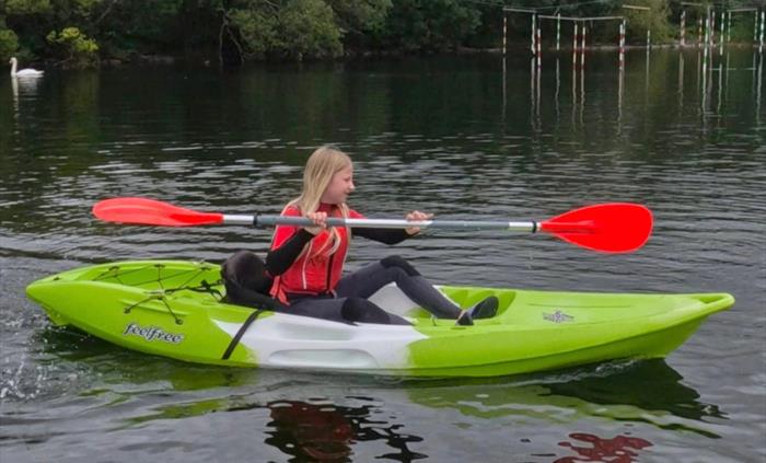Picture of a girl paddling a green kayak